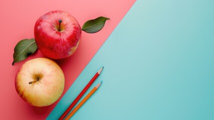 Two apples and pencils on split pink blue background