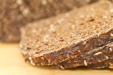 Whole grain bread seeds macro brown isolated on a brown cutting board
