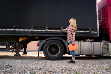 Female truck driver inspecting trailer before the road 