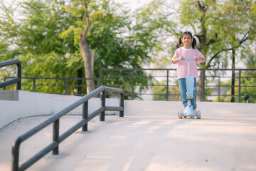 A young girl riding a scooter in a park
