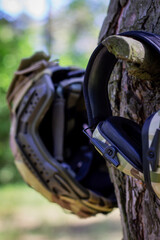 Fototapeta premium A tactical helmet and active tactical headphones hang on a tree branch. Defense of the military, military operations. War in Ukraine