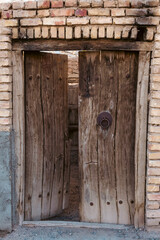 Antique wooden garden door with a plank, knocker and other ornaments  in details
