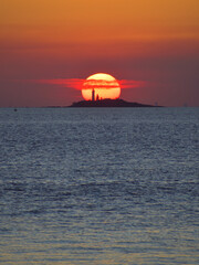 Isla y Faro junto al Sol al atardecer