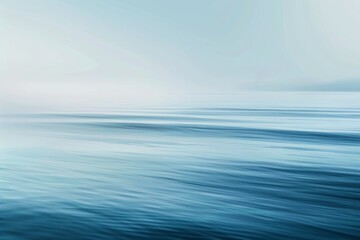 Obraz premium Oceanic Tranquility: A Peaceful Blue Sea with Delicate Clouds Drifting Above.