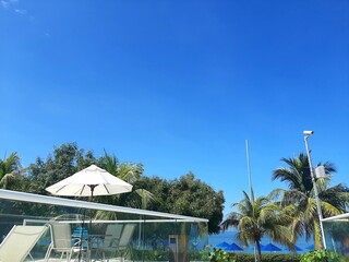 Beautiful swimming pool in hotel resort with blue sky and white cloud