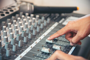 Production sound engineer woman hands adjusting volume equalizer voice, mixing console. DJ sound...