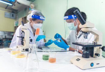 Scientist man woman working together team partner look into Microscope research in science...