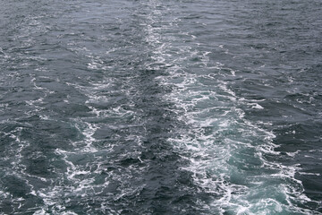 Ripples and patterns on the ocean surface caused by a passing boat