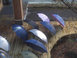 Umbrellas drying on the wooden patio after the rain