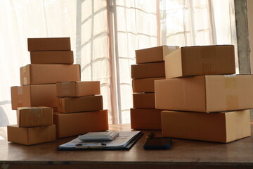 packages await delivery in a small business warehouse. The entrepreneur manages orders online,...