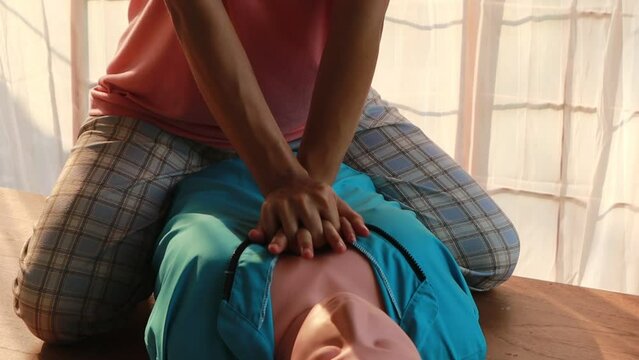 instructor guides an adult in CPR training, importance of first aid emergency medicine. careful compression on a CPR dummy chest, practice life-saving skills, preparing for accidents and disasters.