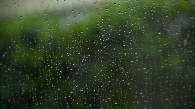 Raindrop on window green background aqua bubble texture. rainfall water surface splash glass. Blurred background falling rain shower windy outdoors. Motion macro raindrops splash design element