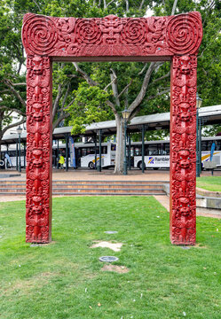 Dunedin, New Zealand - 9 September, 2023: A Maori carved gateway, or waharoa, featuring traditional red designs, located in the Octagon.