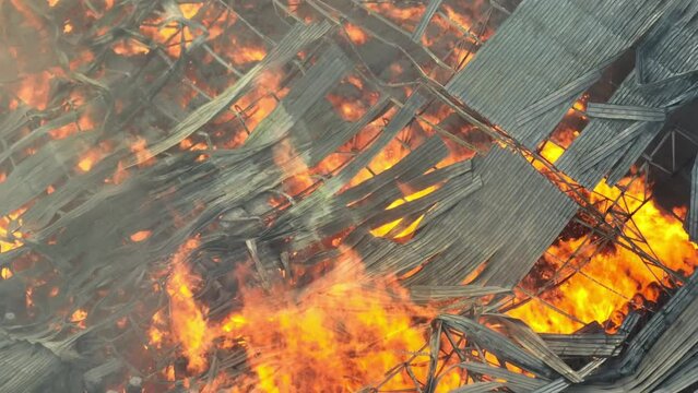 The inferno rages unchecked, consuming the industrial site. Twisted metal structures become molten shadows, swallowed by roaring flames. Smoke blankets the scene, a suffocating shroud of devastation.
