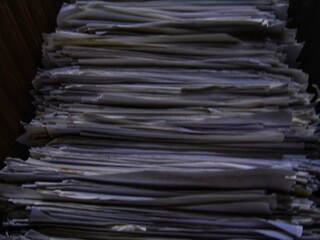 lots of piles of white paper between the office desks