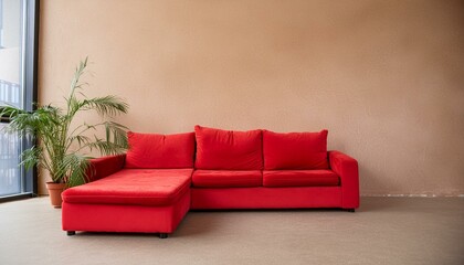 Red modular corner sofa against blank brown stucco wall with copy space. Loft interior design of modern living room, home.