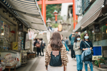 Woman tourist Visiting in Enoshima Island, Fujisawa, Kanagawa, Japan. happy Traveler sightseeing Enoshima Shrine. Landmark and popular for tourists attraction near Tokyo. Travel and Vacation concept