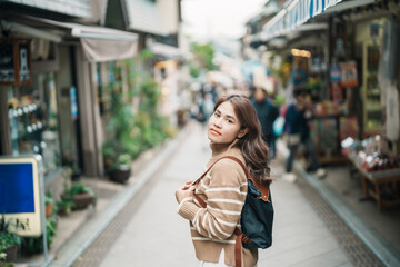 Woman tourist Visiting in Enoshima Island, Fujisawa, Kanagawa, Japan. happy Traveler sightseeing Enoshima Shrine. Landmark and popular for tourists attraction near Tokyo. Travel and Vacation concept