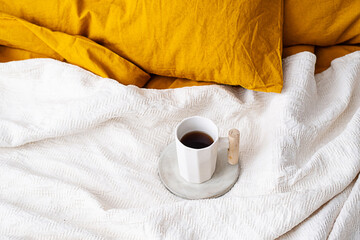 Coffee cup on the bed.