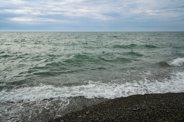 Black Sea on the Sochi coast and a pebble beach on a sunny day with clouds, Sochi, Krasnodar Territory, Russia