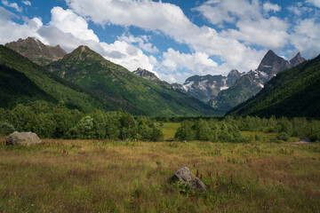 View of the floodplain of the Gonachkhir River in the northern foothills of the Caucasus Mountains near the village of Dombay on a sunny summer day, Karachay-Cherkessia, Russia