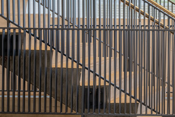 Close-up photo of a modern gray metal railing and concrete stair case between floors. 
