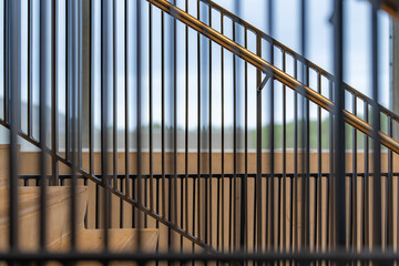 Close-up photo of a modern gray metal railing and concrete stair case between floors. 
