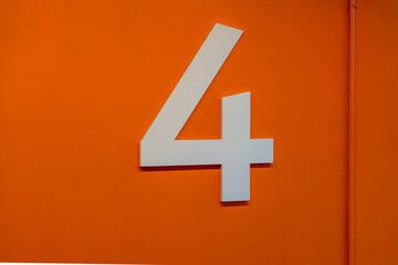 Floor level 4 in a parking ramp, garage, car parking with a large white number on an orange background.	