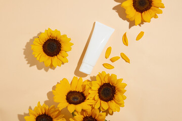 Blank label tube in white color flat lay on light pink background, decorated by scattered...