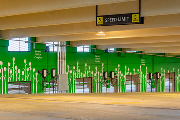 Close-up of electrical vehicle charging stations within a new concrete parking garage.
