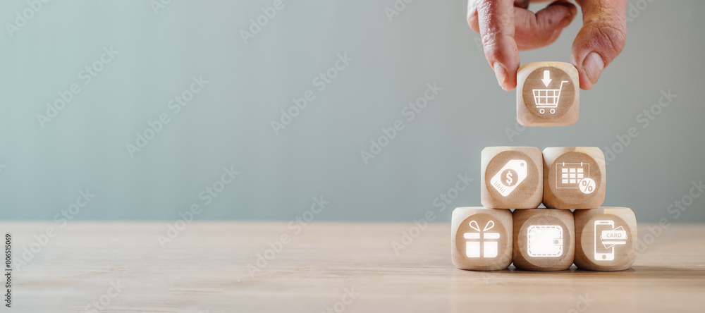 Poster add to cart concept, hand holding wooden block on desk with add to cart icon on virtual screen.