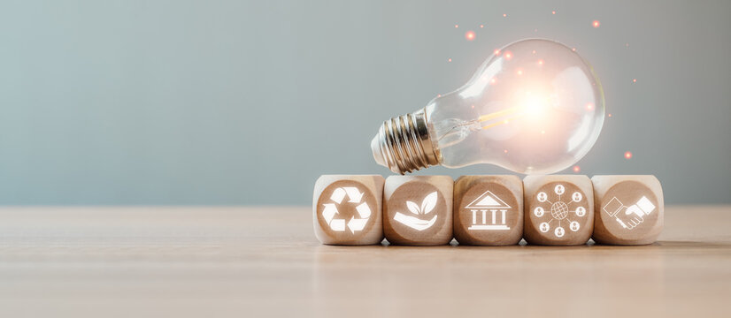 ESG, Environment social governance investment business concept, Wooden block and light bulb on desk with environment social governance icon on virtual screen.