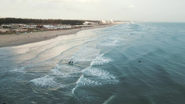 Waves crashing on Miramar Beach in Tampico, Mexico, with several people enjoying the Gulf of Mexico.