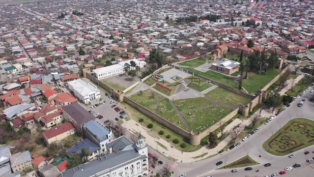 Scenic view from drone of central areas of Telavi city overlooking medieval walled Batonis Tsikhe fortress on spring day, Georgia