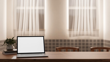 A close-up image of a laptop white screen mockup on a wooden table in a cozy Scandinavian room.