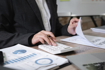 Asian female accountant working on calculations on table in office