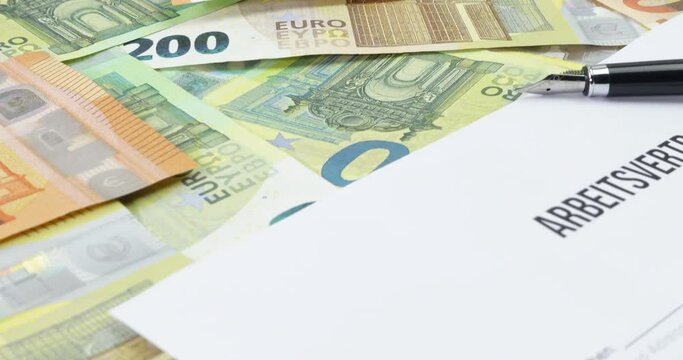 Euro Geldscheine und ein Arbeitsvertrag