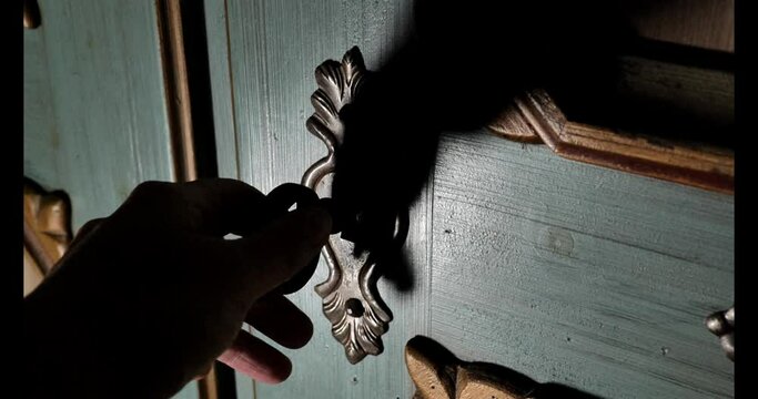 hand opens a wooden antique door with an old key to reveal the secrets of a dark room. atmosphere of mysticism and mystery. 4k footage