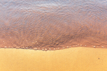 Soft wave of the sea on the sandy beach.