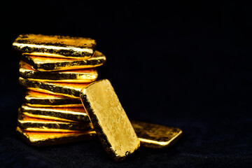 Close up photo a gold bars on black background, copy space