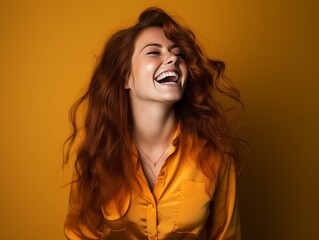A woman with long hair is smiling and laughing while wearing color clothing