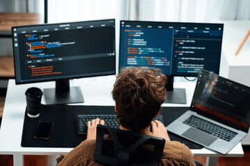 IT developer working online software development on pc monitors at modern home office on coding...