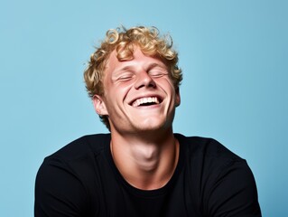 Fototapeta premium A man with blonde hair is smiling and laughing
