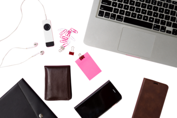 creative layout of work desk with laptop, wallet, mobile phone, notebook, music player, sticky note, paper clip isolated