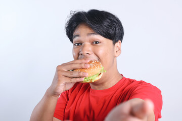 Potrait Of Selfie Excited Young Asian Man Eating Burger Isolated On White Background