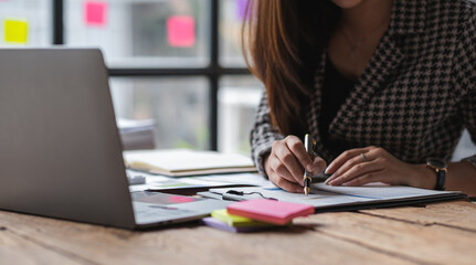 Close-up view of Asian businesswoman working online and planning financial calculation data working...