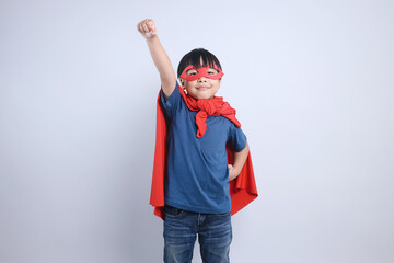 Asian Little Boy Wearing Superhero Costume Raise His Hand Up Isolated on Gray Background