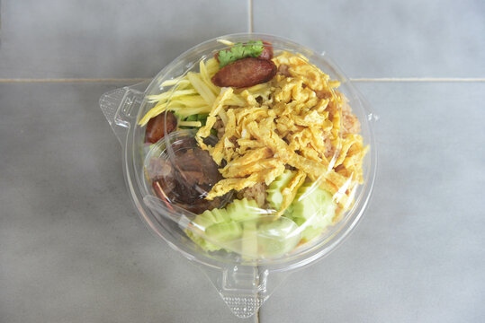 Rice mixed with mango shrimp paste in a plastic box  