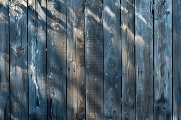 Detailed view of a wooden fence with a tall tree in the background, under sunlight