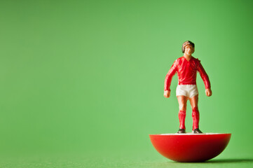 soccer player figurine with red shirt and white trunk